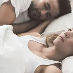 Kobieta leży obok śpiącego partnera, czując się jak sparaliżowana sennie.