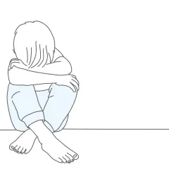 Smutne dziecko skulone na podłodze. Psychologia oceniająca innych często prowadzi do poczucia izolacji i smutku.