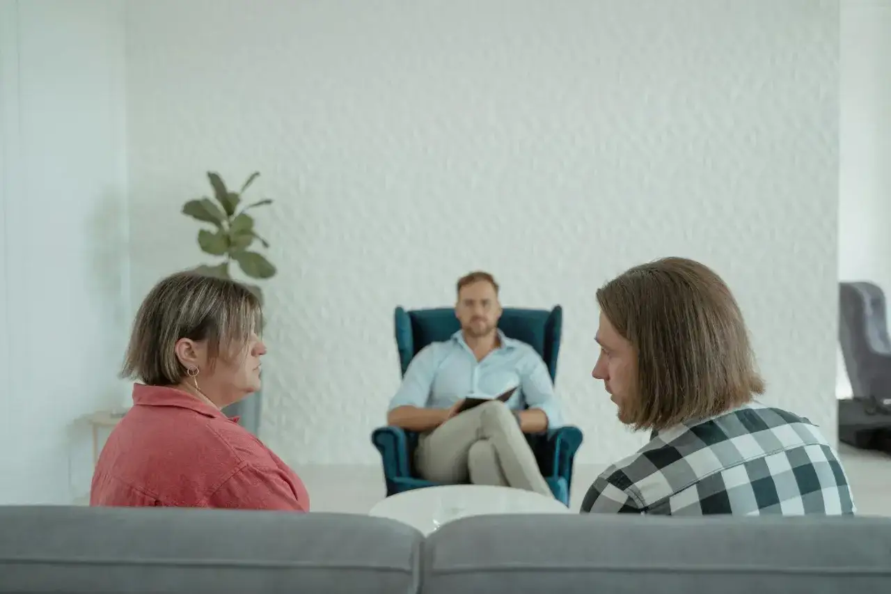 Terapia par. On opowiada o swojej przeszłości, ona słucha. Terapeuta w fotelu notuje.